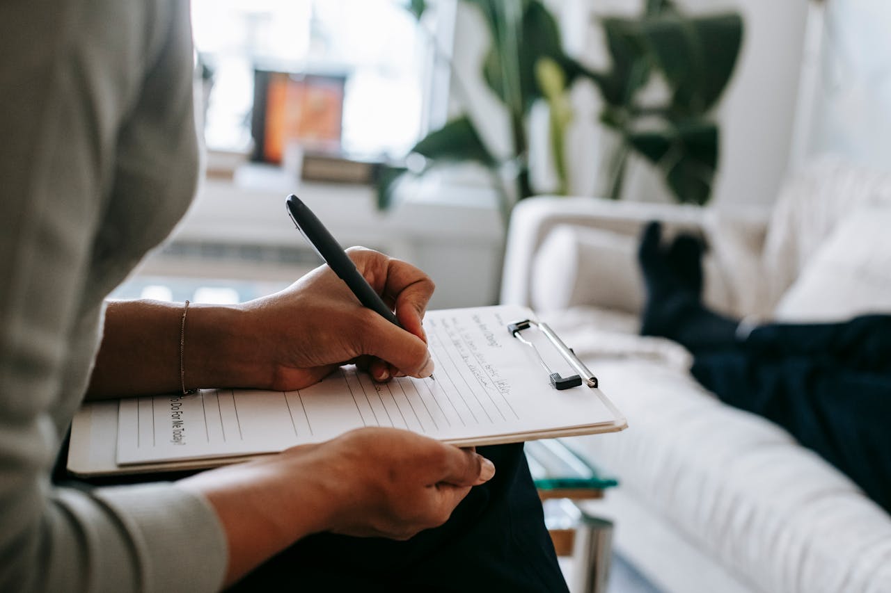 Mastering the First Impression: Your intriguing post title goes here Unrecognizable ethnic female therapist taking notes on clipboard while filling out form during psychological appointment with anonymous client lying on blurred background